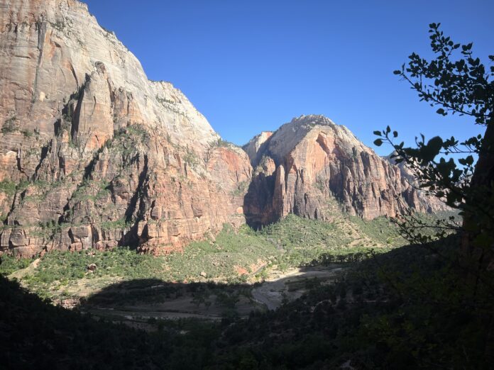 An elevated view of the rock formations of Zion National Park over the Virgin River running through the park.