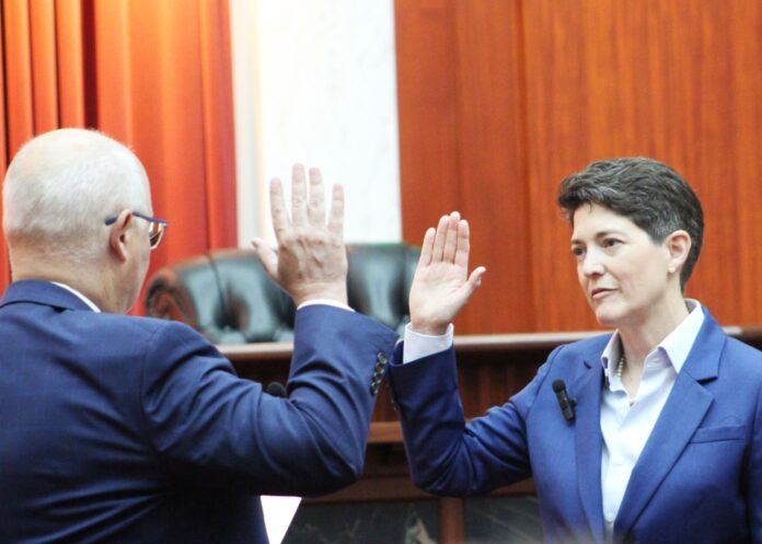 Chief Justice Monica Márquez holds her right hand up in a courtroom as she is sworn in to her new position as the Colorado Supreme Court Chief Justice.