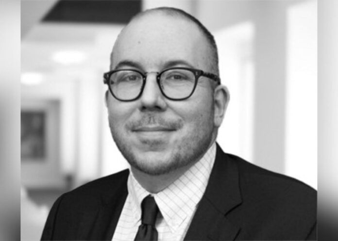 A black and white headshot of BCLP partner James English in a formal suit and tie.